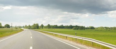Bir yaz günü tarla ve orman boyunca (yeni asfalt yol) boş bir otoyoldur. Yağmurdan önce dramatik fırtına bulutları. Turizm, yol gezisi, özgürlük, tatiller, lojistik, uzak yerler kavramları