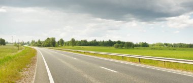 Bir yaz günü tarla ve orman boyunca (yeni asfalt yol) boş bir otoyoldur. Yağmurdan önce dramatik fırtına bulutları. Turizm, yol gezisi, özgürlük, tatiller, lojistik, uzak yerler kavramları