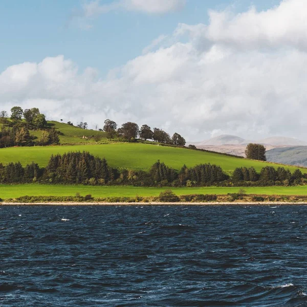 クライド川の第一付近の緑の丘 セーリングボートからのパノラマビュー 嵐の後の劇的な空 イギリスのスコットランド 旅行先 エコツーリズム 純粋な自然 大気の風景 — ストック写真