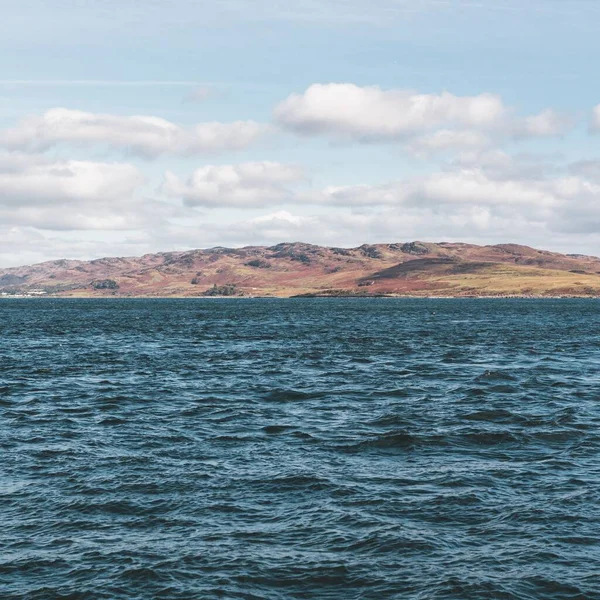 Yat manzaralı Jura adasının batı kıyısındaki kayalık kıyılara (uçurumlara) yelken açmak. Parlak bulutlu dramatik günbatımı gökyüzü. Inner Hebrides, İskoçya, İngiltere. Seyahat yerleri, işaretler