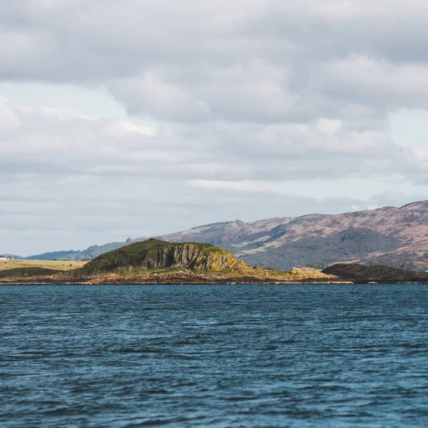 Yat manzaralı Jura adasının batı kıyısındaki kayalık kıyılara (uçurumlara) yelken açmak. Parlak bulutlu dramatik günbatımı gökyüzü. Inner Hebrides, İskoçya, İngiltere. Seyahat yerleri, işaretler