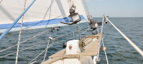 Herreshoff designed old classic yacht sailing in an open sea. Wooden teak deck. View to the mast and sails. Ketch sailboat. North American boat building traditions. Cruise, vacations, regatta, sport