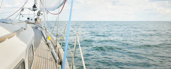 Herreshoff designed old classic yacht sailing in an open sea. Wooden teak deck. View to the mast and sails. Ketch sailboat. North American boat building traditions. Cruise, vacations, regatta, sport