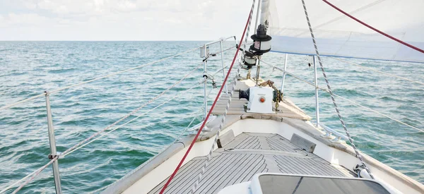 Herreshoff designed old classic yacht sailing in an open sea. Wooden teak deck. View to the mast and sails. Ketch sailboat. North American boat building traditions. Cruise, vacations, regatta, sport