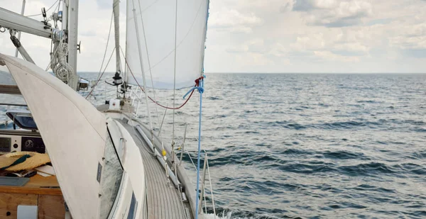 Herreshoff designed old classic yacht sailing in an open sea. Wooden teak deck. View to the mast and sails. Ketch sailboat. North American boat building traditions. Cruise, vacations, regatta, sport