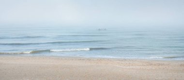 Güneşin doğuşunda sisli bir havada Baltık Denizi manzarası. Kumsal, kum tepeleri. Yumuşak güneş ışığı. Idyllic yaz deniz manzarası. Doğa, çevre, tatiller, eko-turizm, yürüyüş ve keşif kavramları