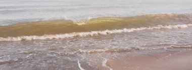 Güneş doğarken sisli bir havada Baltık Denizi kıyısından panoramik manzara. Dalgalar, sıçramalar, su yüzeyi. Yumuşak güneş ışığı, açık mavi gökyüzü. Idyllic yaz deniz manzarası. Saf doğa, çevre, ekoloji, eko-turizm