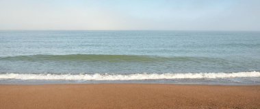 Güneşin doğuşunda sisli bir havada Baltık Denizi manzarası. Kumsal, kum tepeleri. Yumuşak güneş ışığı. Idyllic yaz deniz manzarası. Doğa, çevre, tatiller, eko-turizm, yürüyüş ve keşif kavramları
