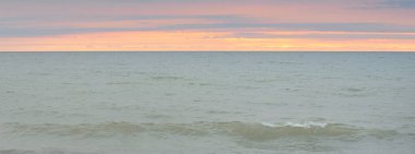 Fırtınadan sonra Baltık Denizi üzerinde dramatik günbatımı gökyüzü. Panoramik manzara. Yumuşak güneş ışığı, parlayan bulutlar. Doğa, çevre, ekoloji