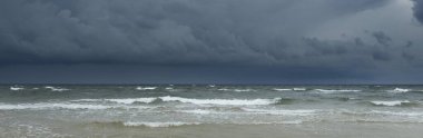 Fırtına sırasında açık bir Baltık denizi. Dramatik gökyüzü, karanlık, parlak bulutlar. Dalgalar, su sıçramaları. Idyllic deniz manzarası. Kış, iklim değişikliği, doğa, kararsız hava, tehlike