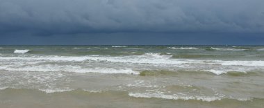 Fırtına sırasında açık bir Baltık denizi. Dramatik gökyüzü, karanlık, parlak bulutlar. Dalgalar, su sıçramaları. Idyllic deniz manzarası. Kış, iklim değişikliği, doğa, kararsız hava, tehlike