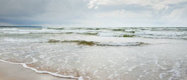 Fırtınadan sonra Baltık kıyıları. Dramatik gökyüzü, parlayan bulutlar. Resimli panoramik manzara. Doğa, çevre, ekoloji, eko-turizm, yürüyüş, keşif kavramları
