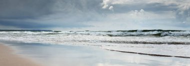Fırtınadan sonra Baltık kıyıları. Dramatik gökyüzü, parlayan bulutlar. Resimli panoramik manzara. Doğa, çevre, ekoloji, eko-turizm, yürüyüş, keşif kavramları