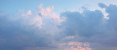 Fırtınadan sonra parlayan pembe ve altın bulutlu açık mavi gökyüzü. Dramatik gün batımı bulutları. Sanat, meteoroloji, cennet, umut, barış kavramları. Grafiksel kaynaklar, resimsel panoramik manzara