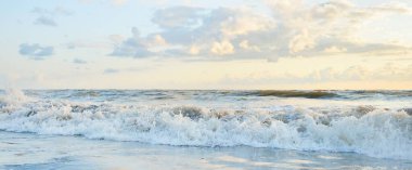 Fırtınadan sonra Baltık kıyıları. Gün batımı, yumuşak güneş ışığı, parlayan bulutlar. Resimli panoramik manzara. Doğa, çevre, ekoloji, eko-turizm, yürüyüş, keşif kavramları