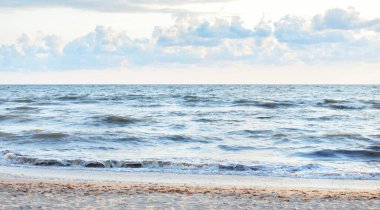 Fırtınadan sonra Baltık kıyıları. Gün batımı, yumuşak güneş ışığı, parlayan bulutlar. Resimli panoramik manzara. Doğa, çevre, ekoloji, eko-turizm, yürüyüş, keşif kavramları