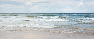 Fırtınadan sonra Baltık kıyıları (kum tepeleri, plaj). Dramatik gökyüzü, parlayan bulutlar. Resimli panoramik manzara. Doğa, çevre, ekoloji, eko-turizm, yürüyüş, keşif kavramları