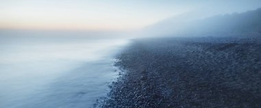 Baltık deniz kıyısının sisli manzarası nefes kesici panoramik. Parlak gökyüzü, gece yarısı güneşi, alacakaranlık. Resimli bir manzara var. Rüya gibi bir manzara. Saf doğa, çevre, ekoloji, turizm