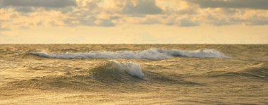 Fırtınadan sonra Baltık kıyıları. Gün batımı, yumuşak güneş ışığı, parlayan bulutlar. Resimli panoramik manzara. Doğa, çevre, ekoloji, eko-turizm, yürüyüş, keşif kavramları