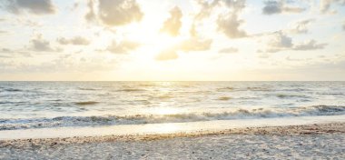 Fırtınadan sonra Baltık kıyıları. Gün batımı, yumuşak güneş ışığı, parlayan bulutlar. Resimli panoramik manzara. Doğa, çevre, ekoloji, eko-turizm, yürüyüş, keşif kavramları