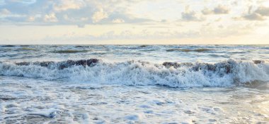 Fırtınadan sonra Baltık kıyıları. Gün batımı, yumuşak güneş ışığı, parlayan bulutlar. Resimli panoramik manzara. Doğa, çevre, ekoloji, eko-turizm, yürüyüş, keşif kavramları