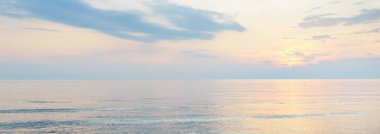 Yağmurdan sonra Baltık Denizi. Dramatik günbatımı gökyüzü, parlayan pembe ve altın fırtına bulutları. Resimli panoramik manzara. Doğa, çevre, değişken hava, kasırga