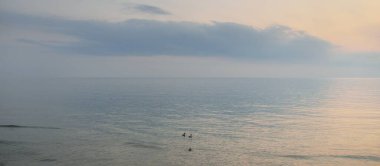 Yağmurdan sonra Baltık Denizi. Dramatik günbatımı gökyüzü, parlayan pembe ve altın fırtına bulutları. Resimli panoramik manzara. Doğa, çevre, değişken hava, kasırga