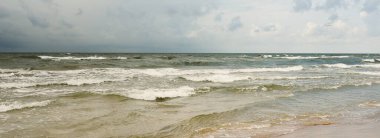 Fırtınadan sonra Baltık kıyıları (kum tepeleri, plaj). Dramatik gökyüzü, parlayan bulutlar. Resimli panoramik manzara. Doğa, çevre, ekoloji, eko-turizm, yürüyüş, keşif kavramları