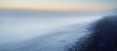 Baltık deniz kıyısının sisli manzarası nefes kesici panoramik. Parlak gökyüzü, gece yarısı güneşi, alacakaranlık. Resimli bir manzara var. Rüya gibi bir manzara. Saf doğa, çevre, ekoloji, turizm
