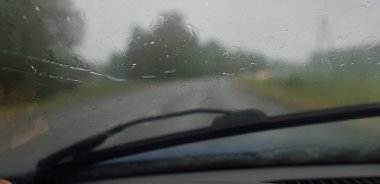 Bir yaz günü tarla ve orman boyunca (asfalt yol) bomboş bir otoyol. Dramatik fırtına bulutları, yağmur. Turizm, yolculuk, özgürlük, tatiller, lojistik, ücra yerler kavramları. Arabadan bak.