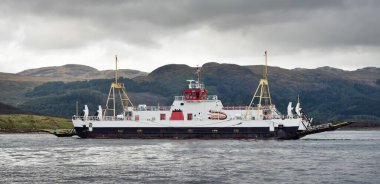 Ro-ro yolcu gemisi bulutlu bir günde kayalık göl kıyısında yol alıyor. Rothesay, İskoçya, İngiltere. Denizcilik gemisi, ulaşım, feribot bağlantısı, seyahat, turizm temaları