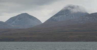 Rocky gölü kıyıları, dağ zirveleri, dağlar, vadiler ve tepeler. Yelkenliden panoramik manzara. Dramatik bir gökyüzü. İskoçya, İngiltere. Atmosferik manzara. Seyahat yerleri, dönüm noktaları, yürüyüş, eko-turizm