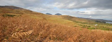 Mountain peaks, valleys and hills of Jura island. Panoramic view. Dramatic sky. Scotland, UK. Atmospheric landscape. Travel destinations, landmarks, hiking, ecotourism, environmental conservation