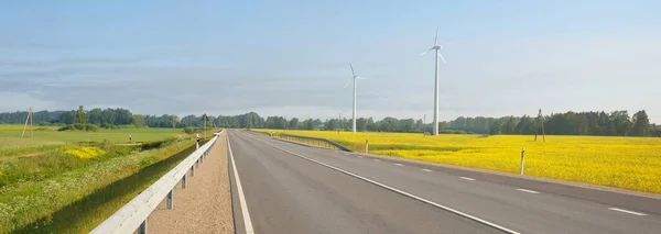 日の出には菜の花畑や森を抜ける高速道路 風力発電機 生態系 生態系 再生可能エネルギー インフラ 自然エネルギー — ストック写真