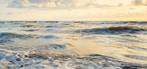 Baltic sea shore after the storm. Sunset, soft sunlight, glowing clouds. Picturesque panoramic scenery. Nature, environment, ecology, ecotourism, hiking, exploring concepts