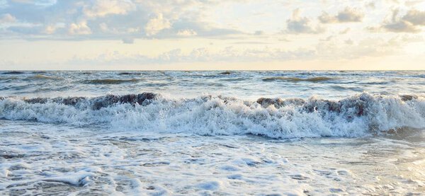 Baltic sea shore after the storm. Sunset, soft sunlight, glowing clouds. Picturesque panoramic scenery. Nature, environment, ecology, ecotourism, hiking, exploring concepts