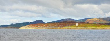 İskoçya, Rothesay 'ın kayalık kıyıları, tepeleri ve vadileri üzerinde dramatik bir gökyüzü. Yelkenliden panoramik manzara. Seyahat merkezleri, turizm, yürüyüş, dönüm noktası, ekoloji, çevre, doğa temaları