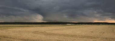 Dramatik gökyüzü, zirai tarlaların ve ormanların üzerindeki kara bulutlar. Kırsal alan. Atmosferik manzara. Sonbaharın başında. Doğa, kararsız hava, ekoloji, çevre, tarım endüstrisi, uzak yerler