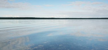 Orman nehri (göl) güneşli bir günde. Clea gökyüzü, kristal berrak suda yansıyor. Idyllic manzara, kırsal manzara. Doğa, ekoloji, eko-turizm, yürüyüş, ekoloji beldesi, yerel turizm