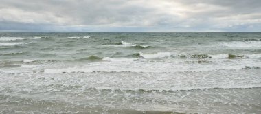 Fırtına sırasında Baltık Denizi. Dramatik gökyüzü, karanlık, parlak bulutlar. Dalgalar, su sıçramaları. Idyllic deniz manzarası. İklim değişikliği, doğa, kararsız hava, ekoloji