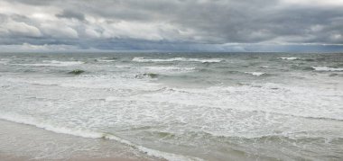 Fırtına sırasında Baltık Denizi. Dramatik gökyüzü, karanlık, parlak bulutlar. Dalgalar, su sıçramaları. Idyllic deniz manzarası. İklim değişikliği, doğa, kararsız hava, ekoloji