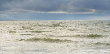 Fırtına sırasında Baltık Denizi. Dramatik gökyüzü, karanlık, parlak bulutlar. Dalgalar, su sıçramaları. Idyllic deniz manzarası. İklim değişikliği, doğa, kararsız hava, ekoloji