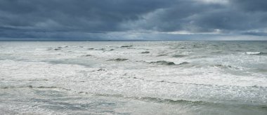 Fırtına sırasında Baltık Denizi. Dramatik gökyüzü, karanlık, parlak bulutlar. Dalgalar, su sıçramaları. Idyllic deniz manzarası. İklim değişikliği, doğa, kararsız hava, ekoloji