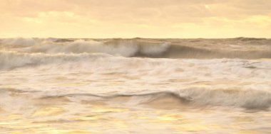Deniz dalgaları ve sıçrama dokusu. Renkli gökyüzü suya yansıyor. Idyllic deniz manzarası. Kavramsal görüntü, uzun pozlama. Resimli bir manzara var. Arkaplan, duvar kağıdı, doğal desen, grafik kaynakları