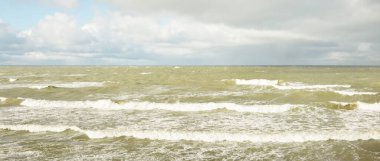 Fırtınadan sonra dramatik günbatımı bulutları altında Baltık Denizi. Dalgalar, su sıçratma. Destansı deniz manzarası. 40-50 deniz mili rüzgar gücü. Kasırga, fırtına, sert hava, meteoroloji, ekoloji, iklim değişikliği