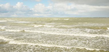 Fırtınadan sonra dramatik günbatımı bulutları altında Baltık Denizi. Dalgalar, su sıçratma. Destansı deniz manzarası. Kasırga, fırtına, sert hava, meteoroloji, ekoloji, iklim değişikliği, doğal olaylar