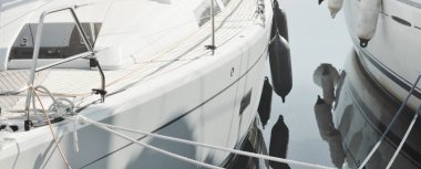 White modern sailboat (for rent and sale) moored to a pier in a yacht marina. Wooden teak deck. Nautical vessel, transportation, amateur sailing, vacations, cruising, recreation concepts