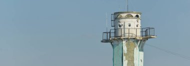 Eski bir deniz feneri. Açık mavi gökyüzü. Panoramik manzara. Şehir manzarası kavramı. Baltık Denizi. Seyahat yerleri, simgeler, mimari, navigasyon, umut ve barış kavramları