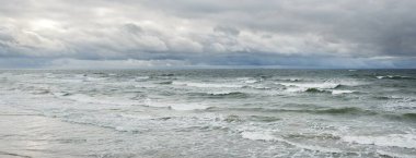 Fırtına sırasında Baltık Denizi. Dramatik gökyüzü, karanlık, parlak bulutlar. Dalgalar, su sıçramaları. Idyllic deniz manzarası. İklim değişikliği, doğa, kararsız hava, ekoloji
