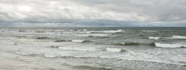 Fırtına sırasında Baltık Denizi. Dramatik gökyüzü, karanlık, parlak bulutlar. Dalgalar, su sıçramaları. Idyllic deniz manzarası. İklim değişikliği, doğa, kararsız hava, ekoloji